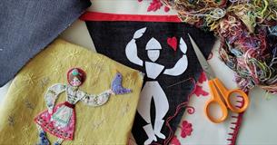 Flatlay image of folk art bunting a selection of coloured yarn
