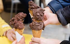 Three people holding chocolate gelato cones