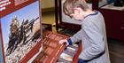 A young boy looks at one of the displays at the museum, playing with an interactive exhibit.
