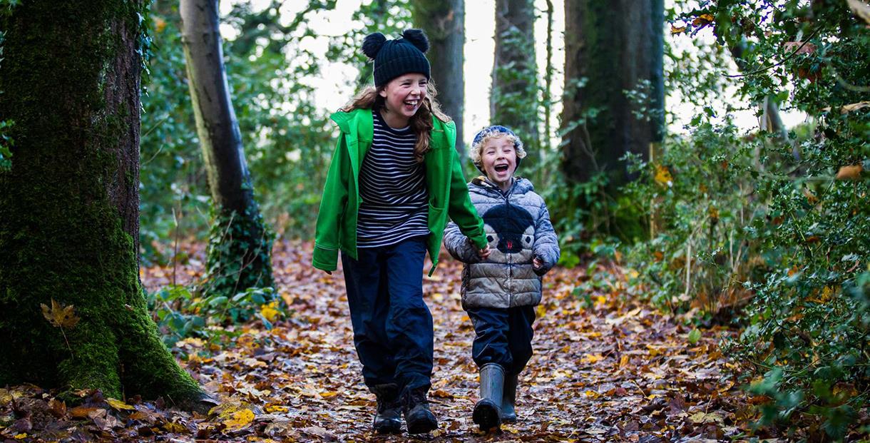 children running in winter woodland (photo Johnny Hathaway for Forestry England)