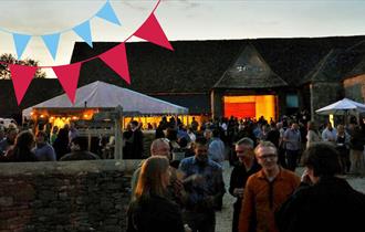beer and bunting at the Cogges barn in the evening with crowds