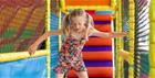 A child balancing on the soft play equipment