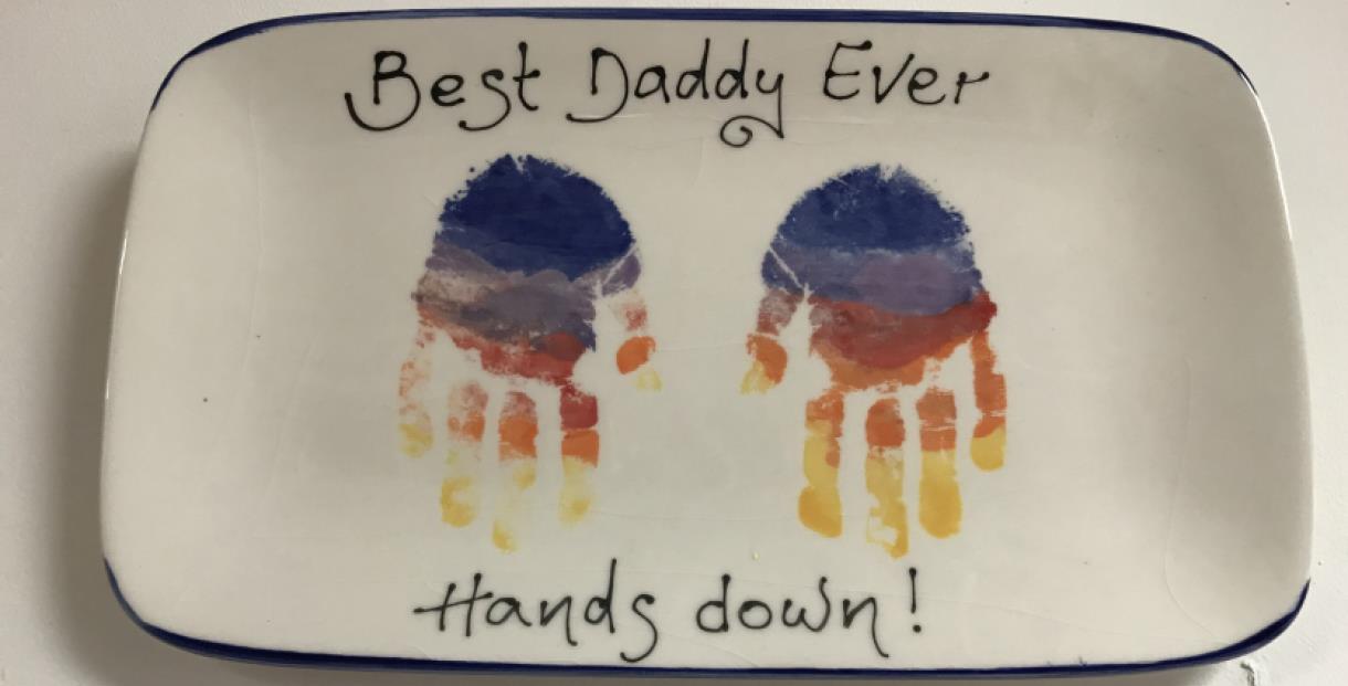 A plate with the words 'best daddy ever, hands down' and two hand prints