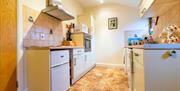 A fully-equipped kitchen with dishwasher, oven,  microwave and fridge/freezer. Dining area.