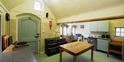 kitchen with two cookers table and storage cupboards