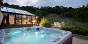 Private 6/7 seater hot tub with lights lit showing the terrace.