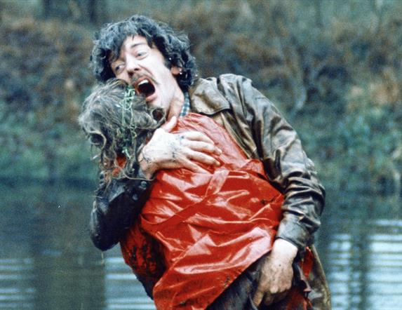 A male character holding someone in his arms.