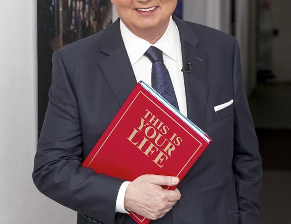 Picture of Eamon Holmes with a red book.