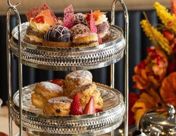 Afternoon Tea tray filled with treats next to Autumn floral display