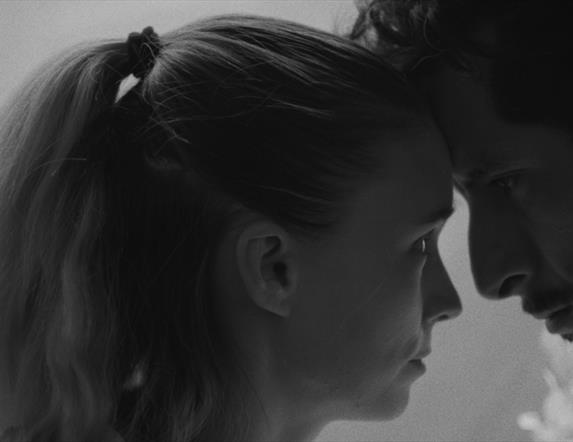 man and woman closely looking at one another