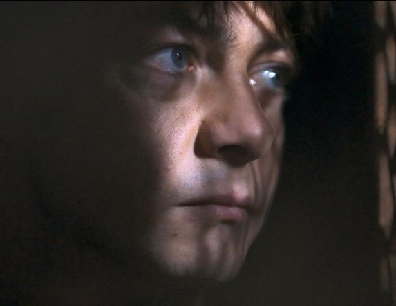 man suspiciously looking through curtains