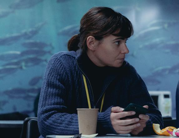 Woman sitting at table with phone