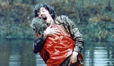 A male character holding someone in his arms.