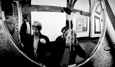 Members of the Dublin band Gilla Band gathered in front of a mirror.