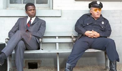 Detective and policeman sitting on a bench