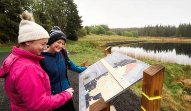 Visitors read information at the Killeter Forest Trails.