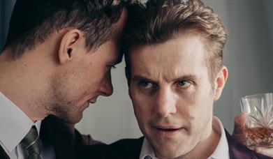 Two men in intimate conversation