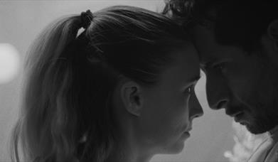 man and woman closely looking at one another
