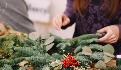 woman designing a pine centerpiece