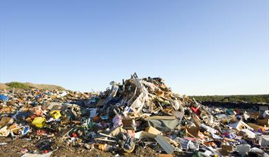 A pile of dumped rubbish with a blue sky