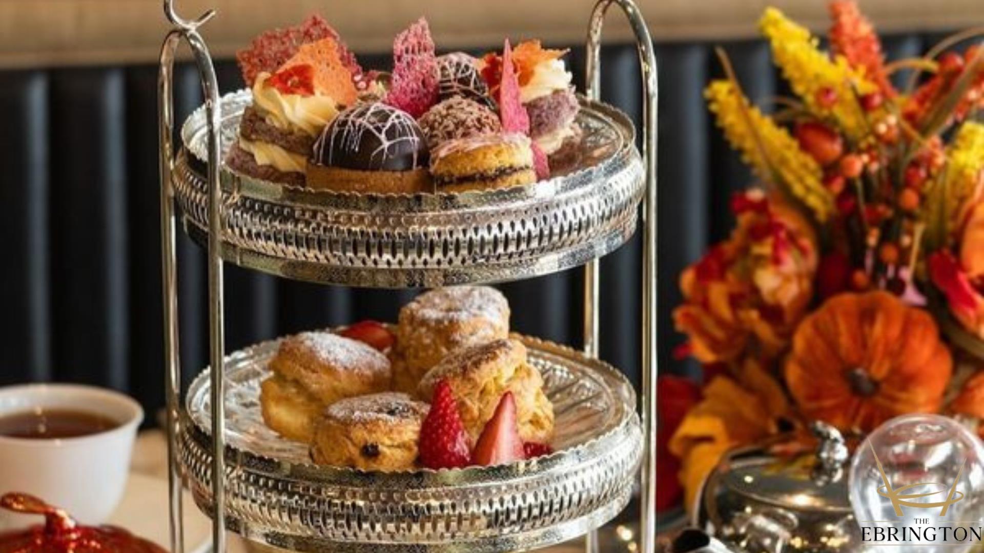 Afternoon Tea tray filled with treats next to Autumn floral display