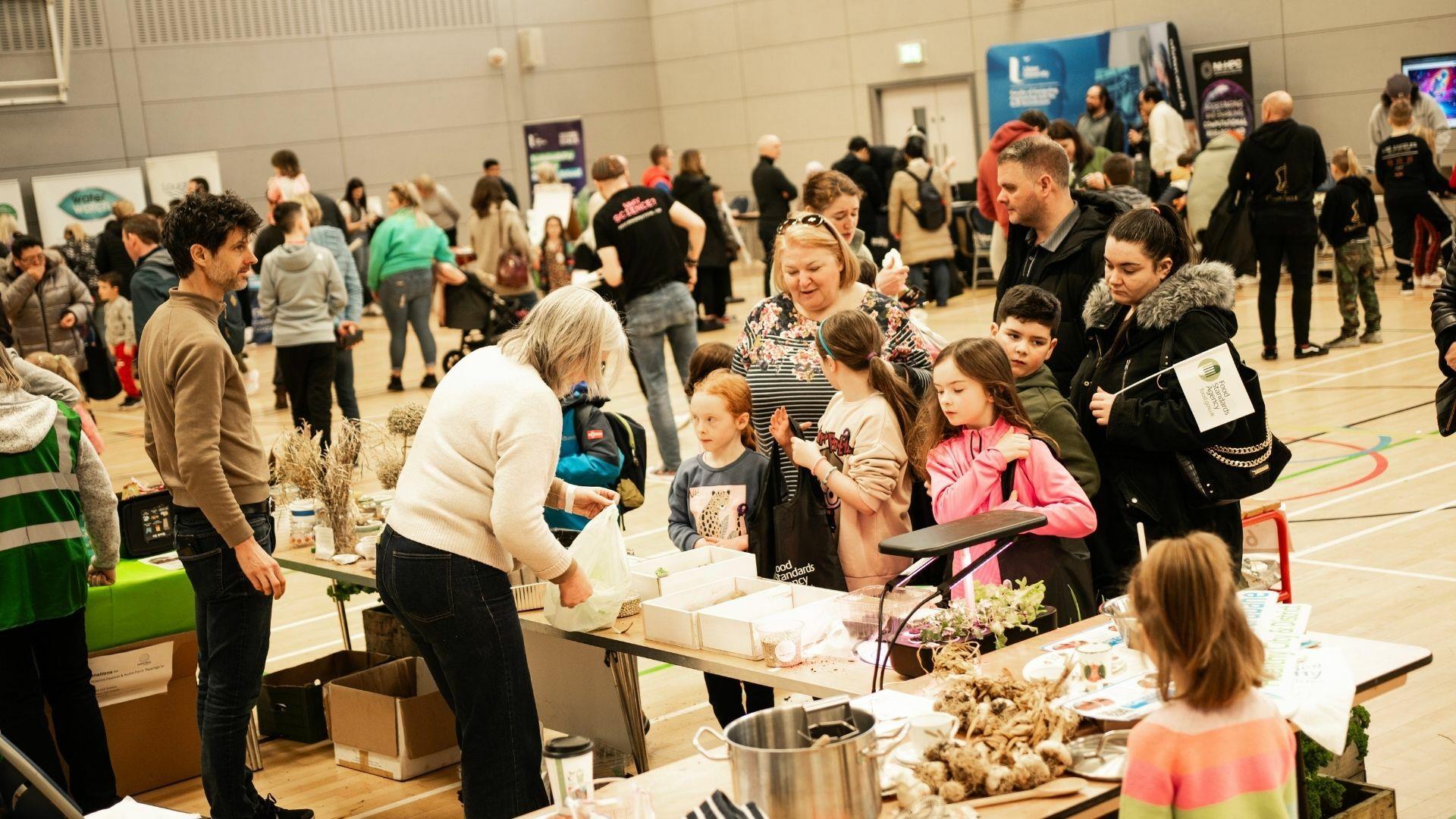 Image of Foyle Arena with tables and people learning about science
