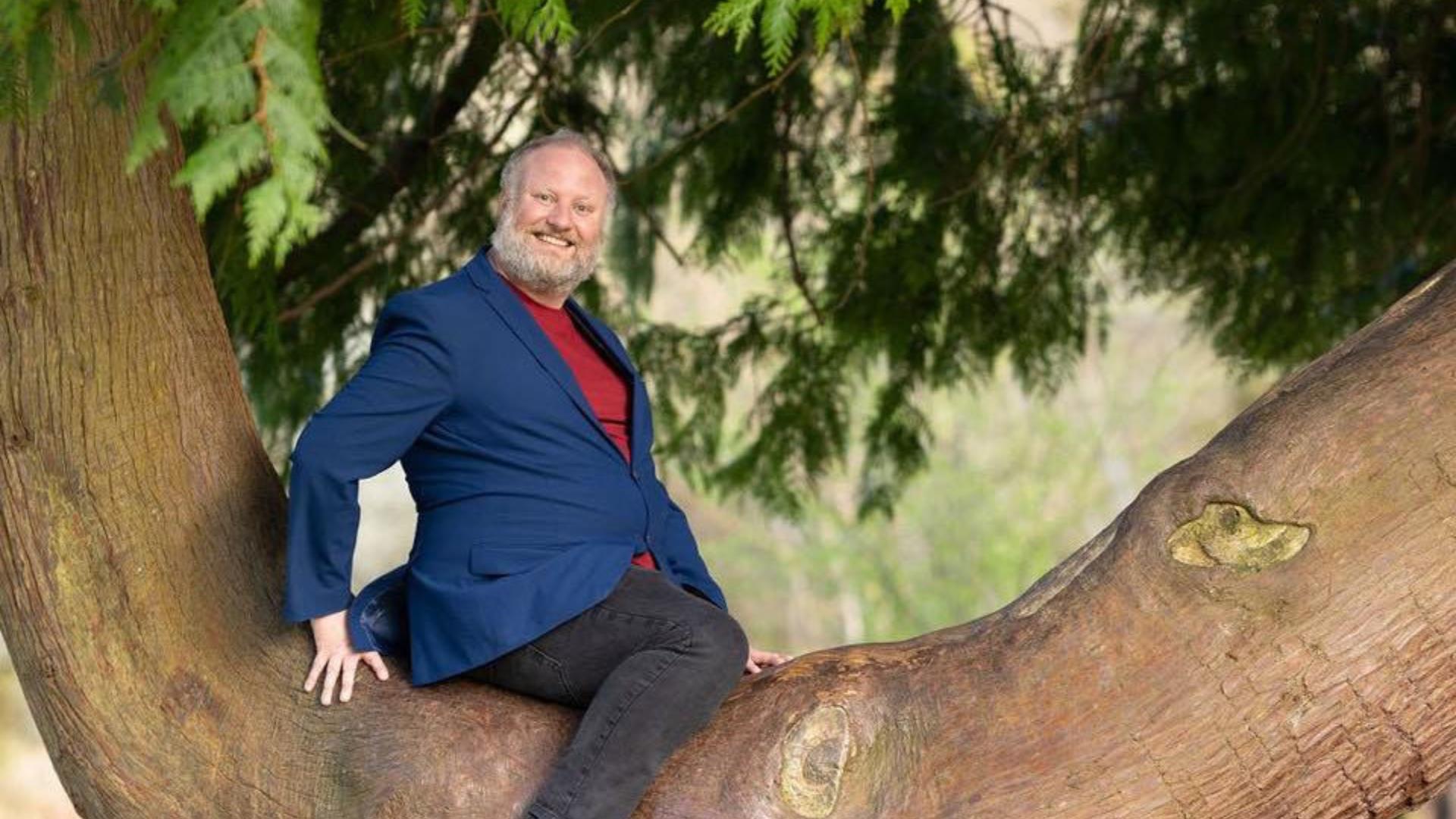 Image of comedian Fred Cooke in a tree