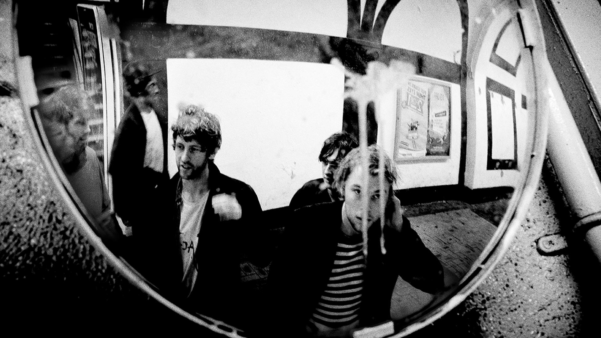 Members of the Dublin band Gilla Band gathered in front of a mirror.