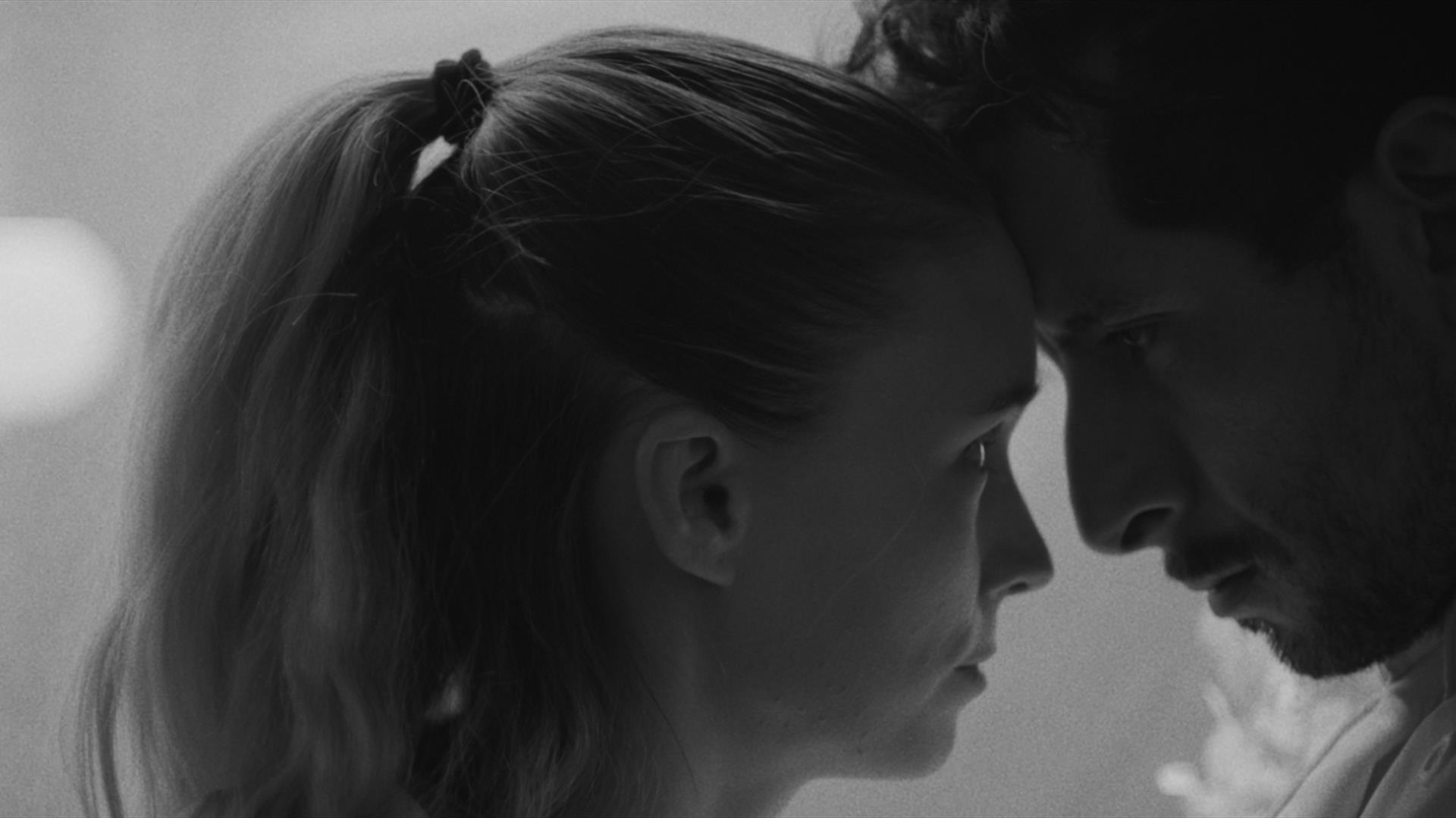 man and woman closely looking at one another