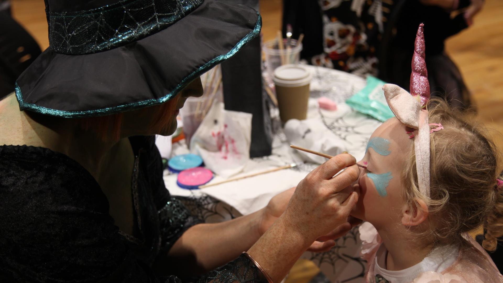 a child getting their face-painted