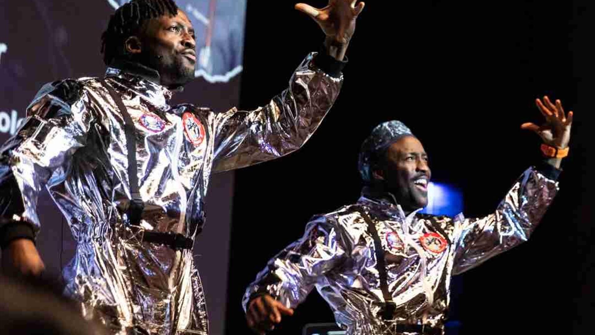 The O Twins dressed as astronauts stand side by side