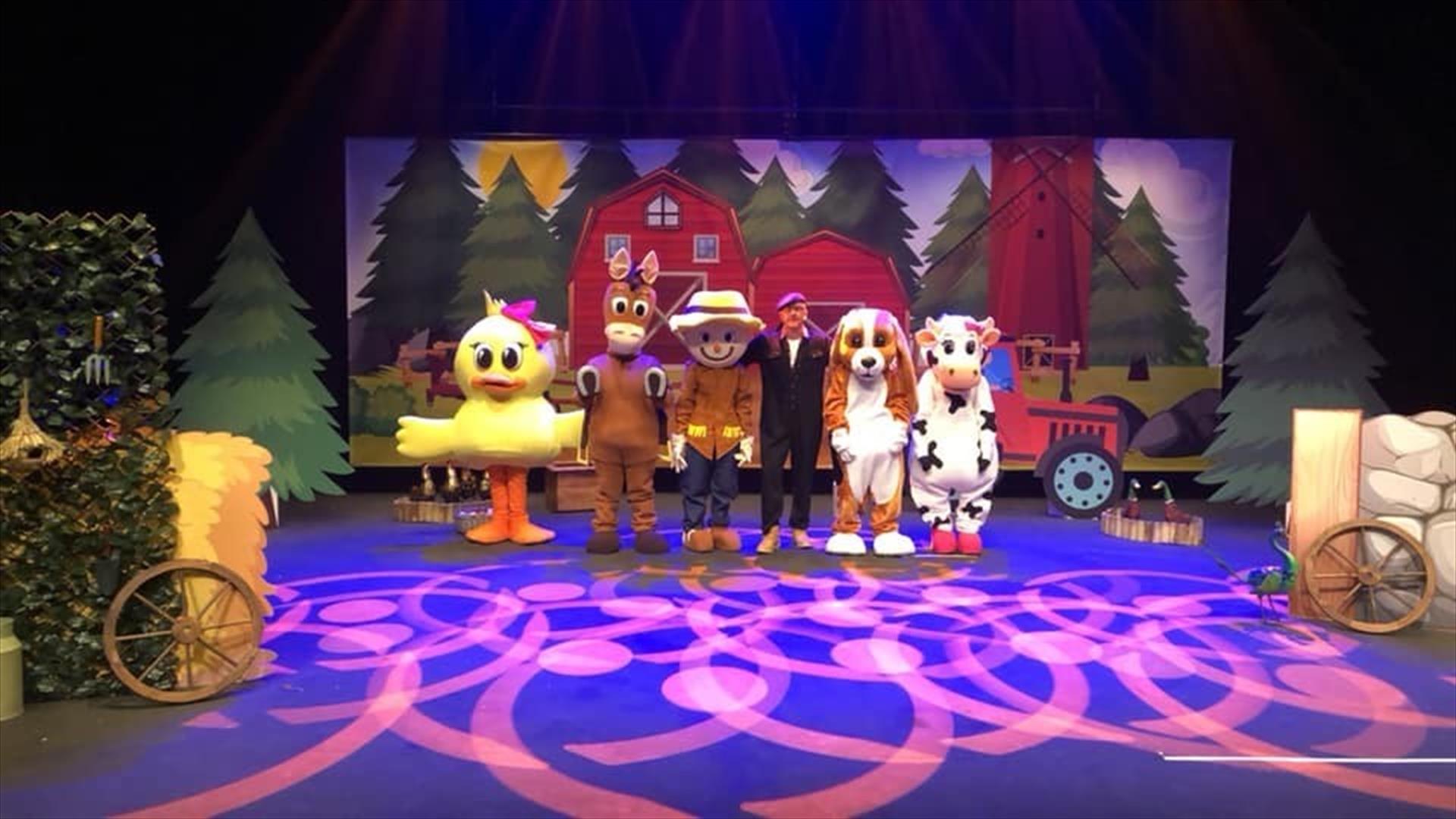 Image shows characters on stage, in front of a farm background