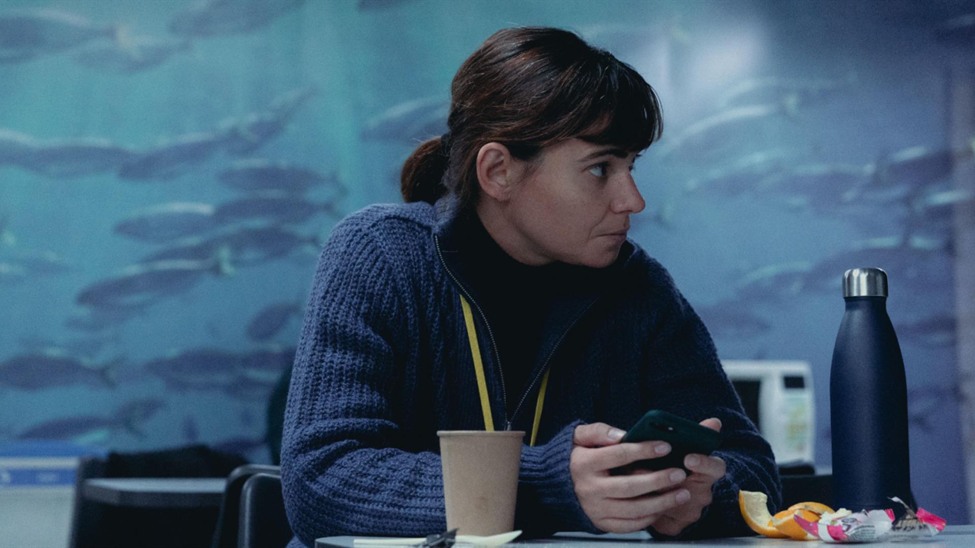 Woman sitting at table with phone