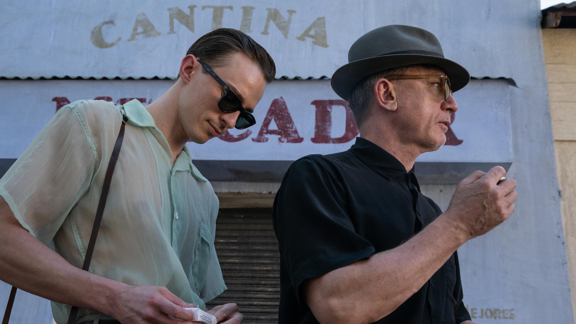 Two men one is smoking the other is holding a camera