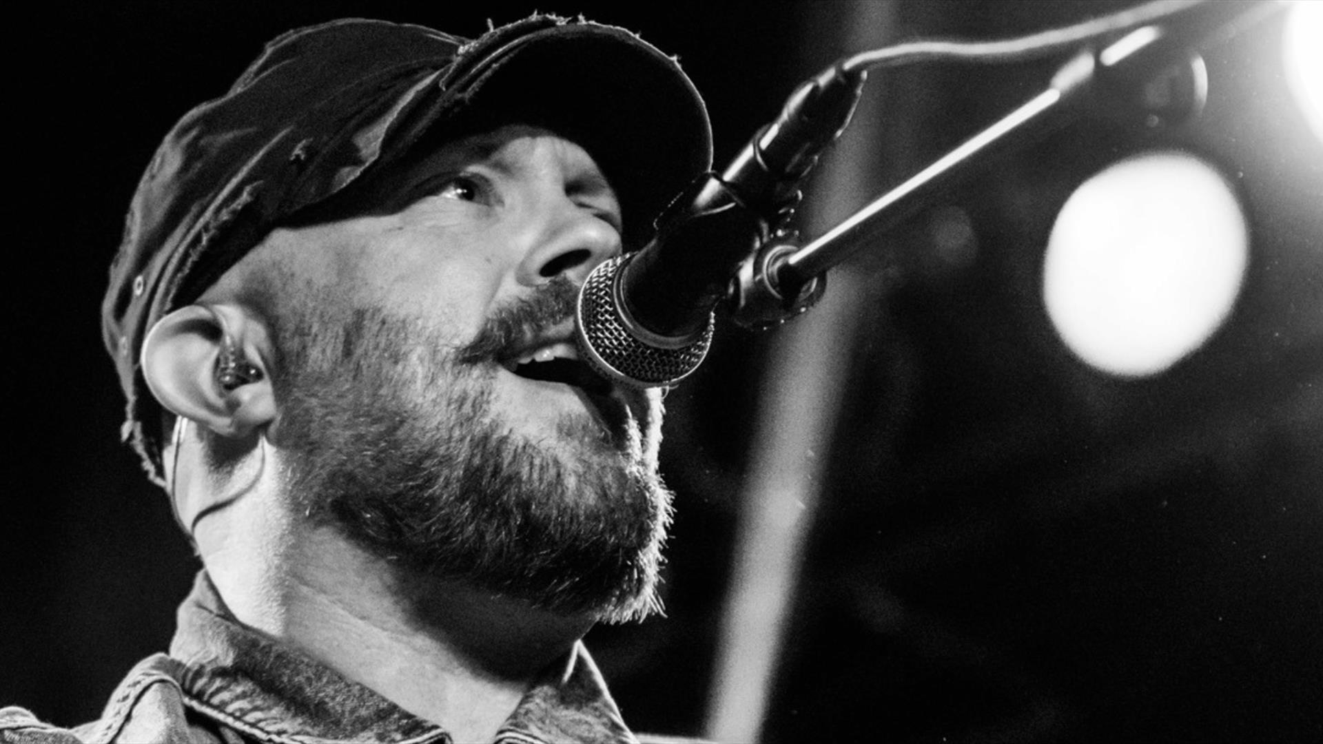 Black and white image of Ryan Sheridan singing through a microphone.