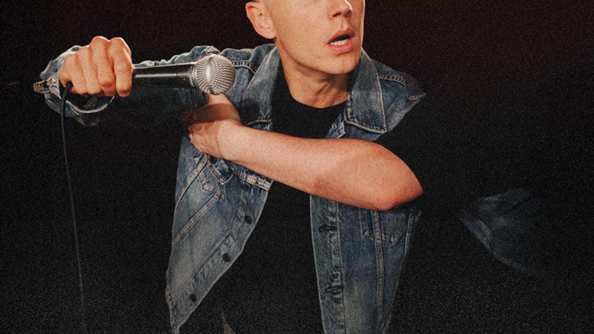 black poster with shane todd holding a microphone