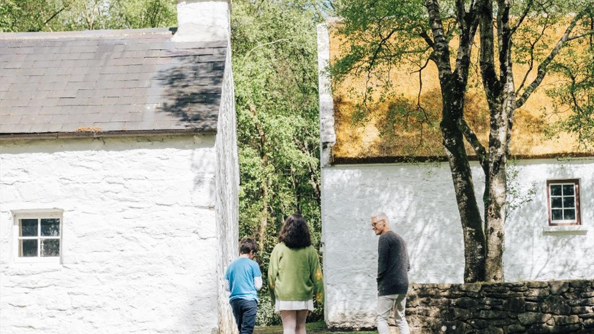 A family enjoying the white cottages at the ulster american folk park