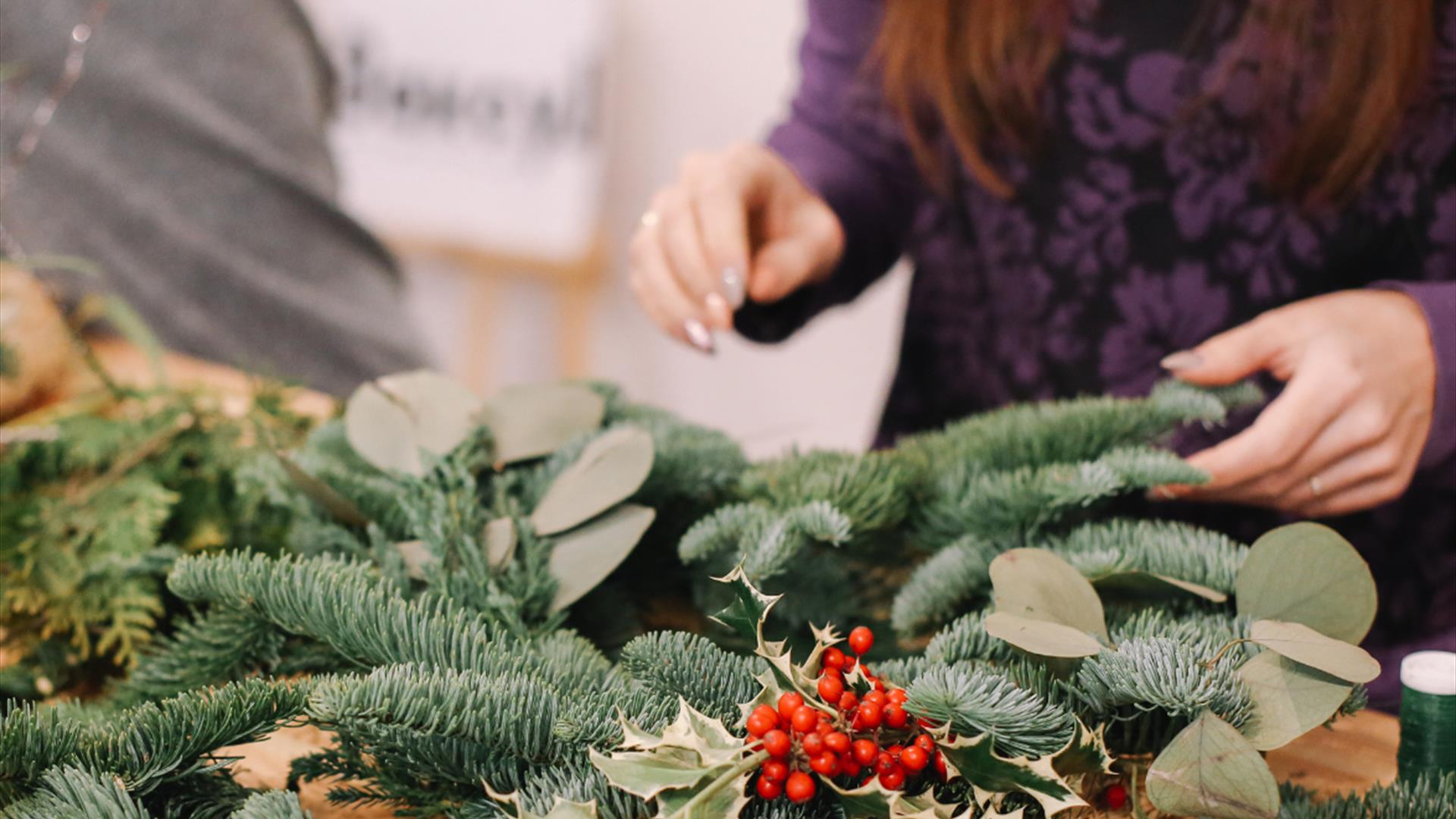 woman designing a pine centerpiece