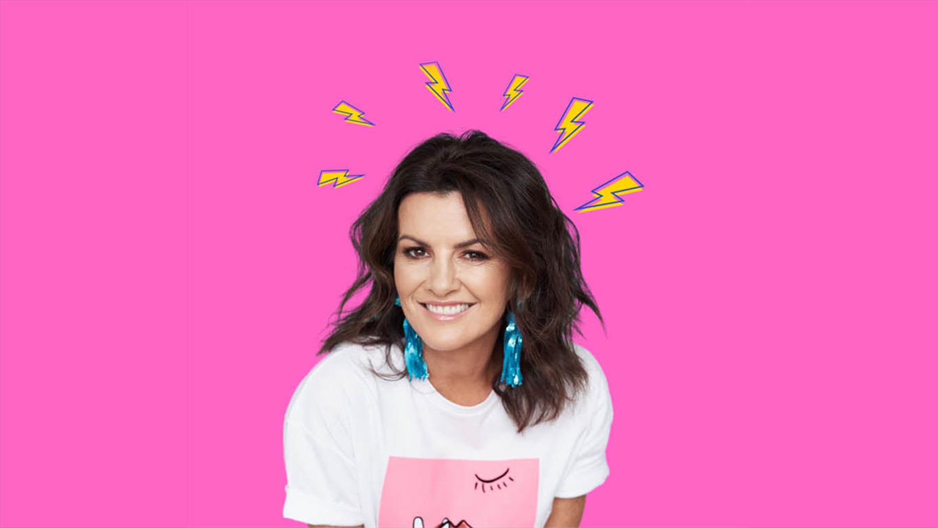 Deirdre Okane is in front of a pink background, wearing a white tshirt with small cartoon lightening bolts around her head