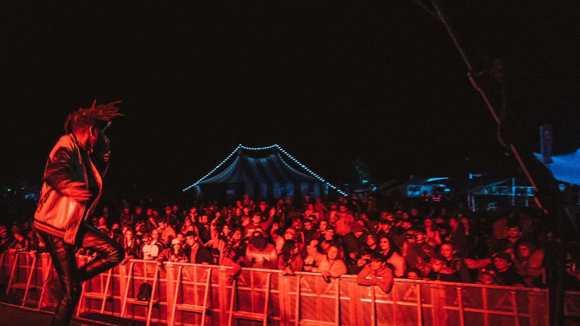 A lively scene from the festival of a performer in front of a crowd.