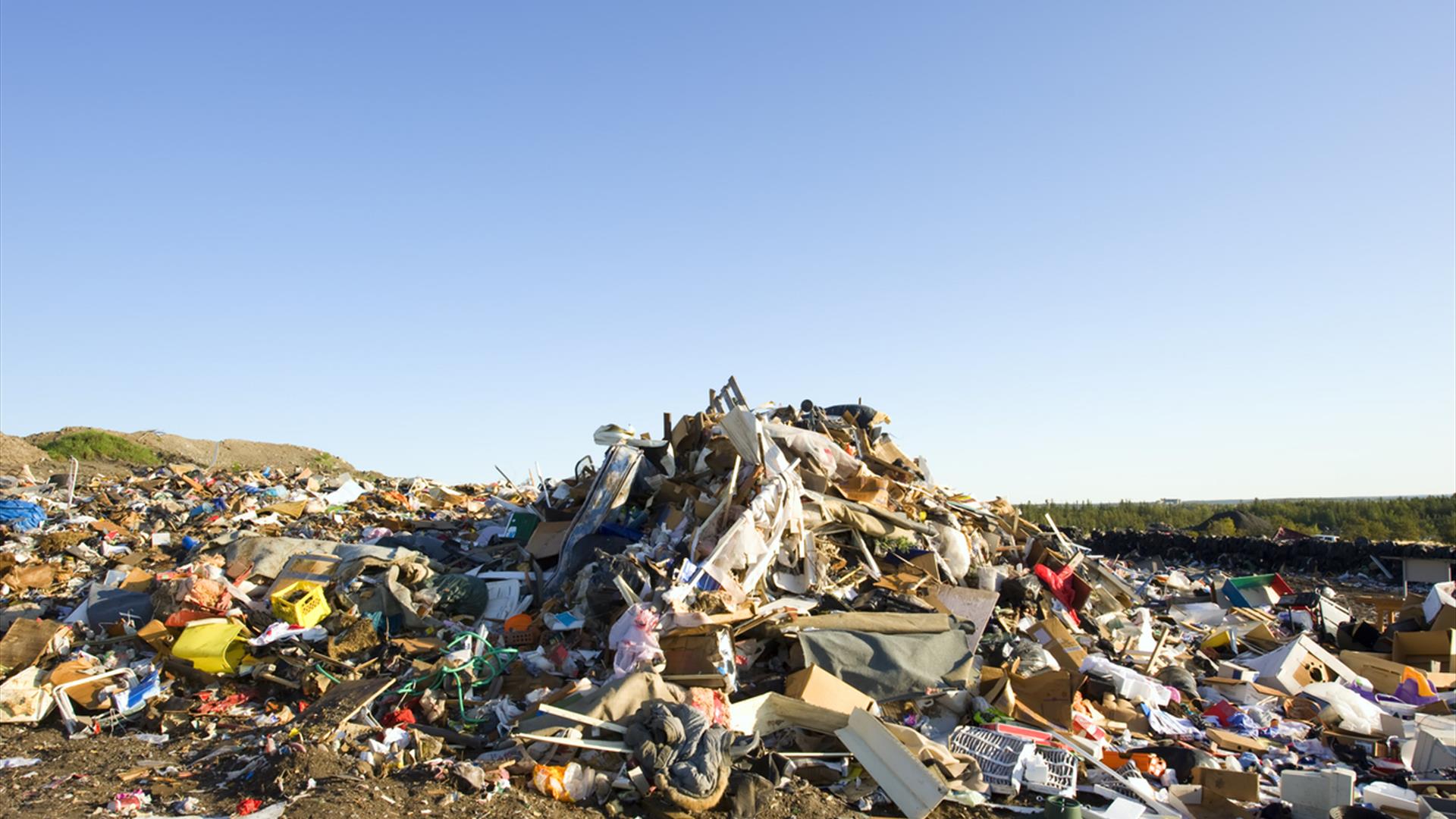 A pile of dumped rubbish with a blue sky