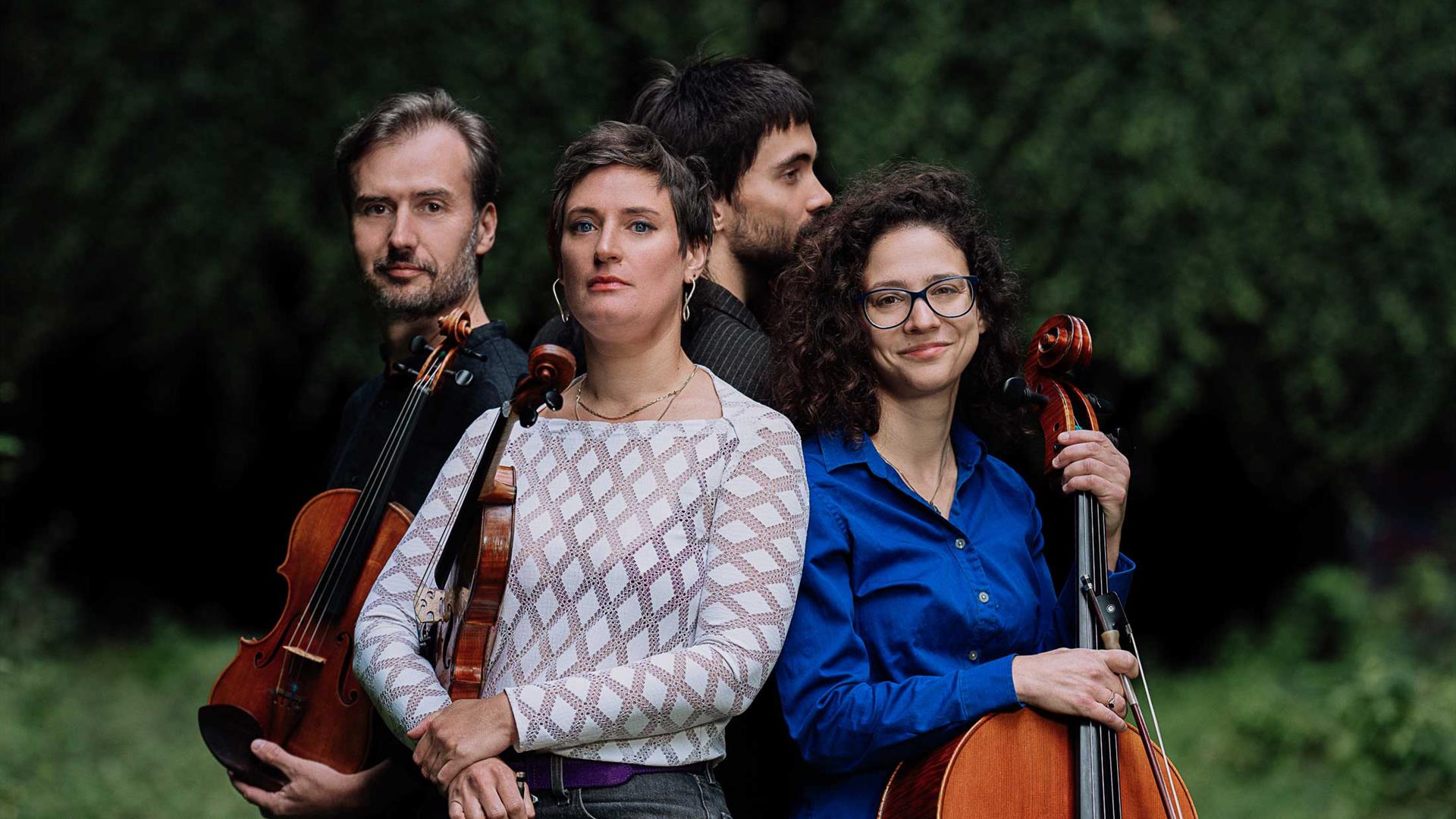 An image of the group posing with their instruments outdoors.