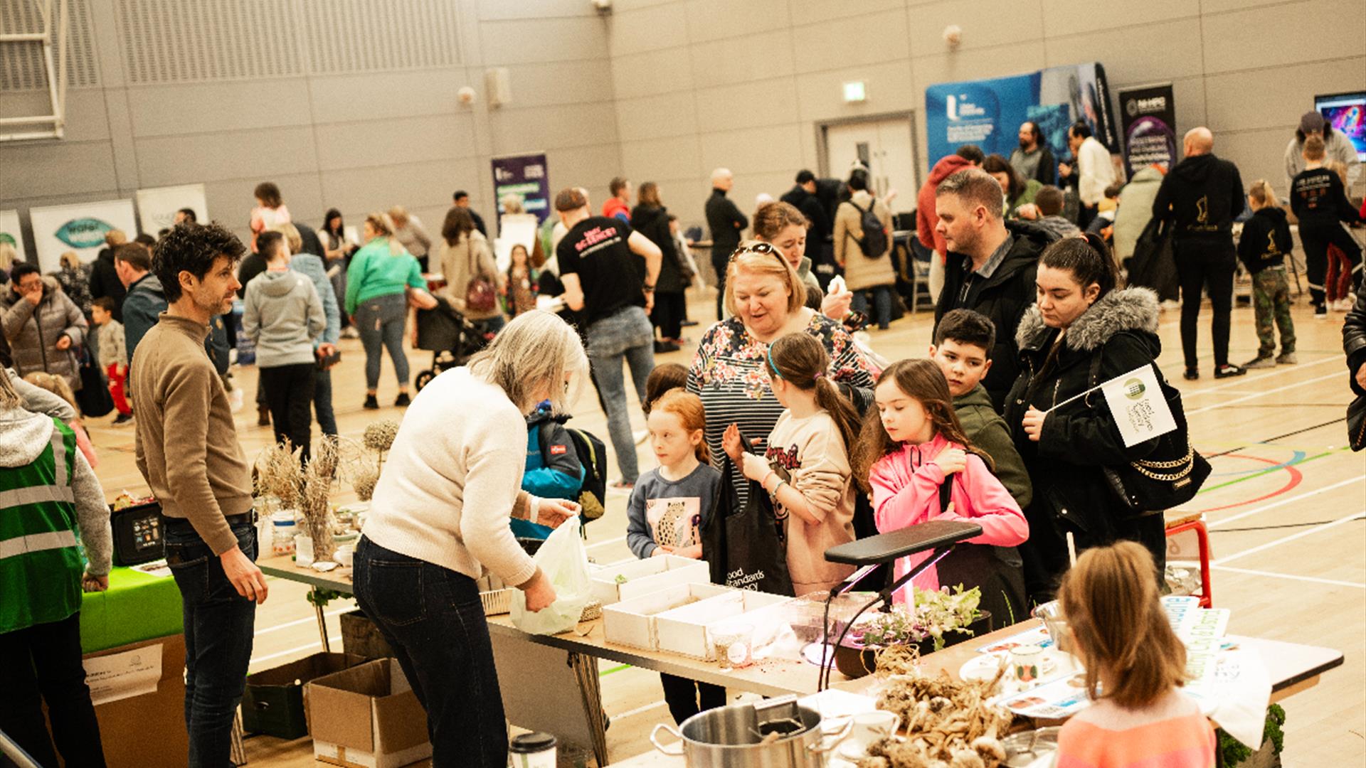 Families with young children  visit some stalls at a science fair