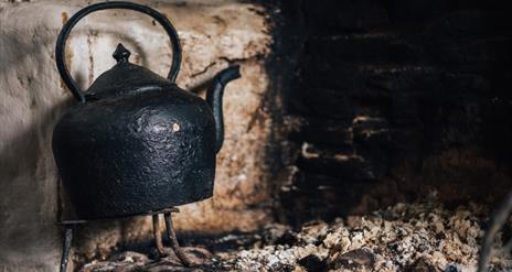 Image of a kettle on the hearth at the Ulster American Folk Park