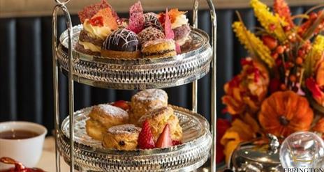 Afternoon Tea tray filled with treats next to Autumn floral display