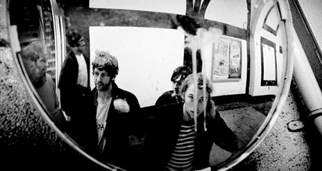 Members of the Dublin band Gilla Band gathered in front of a mirror.