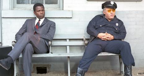 Detective and policeman sitting on a bench