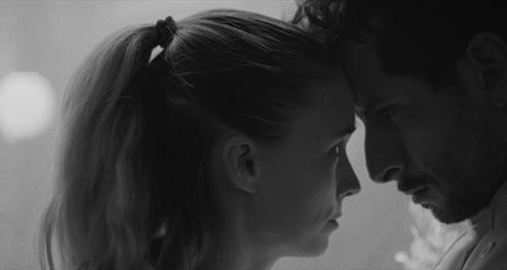 man and woman closely looking at one another