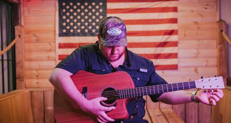 Image of Luke Combs playing guitar