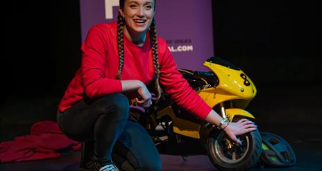 girl in front of a small motorbike